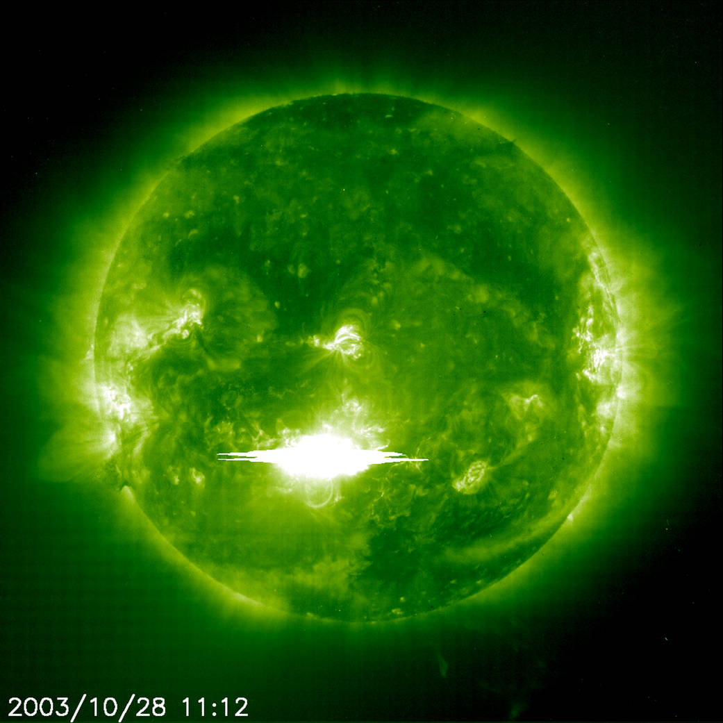 Image of sun from SOHO spacecraft with large, bright flare in lower center