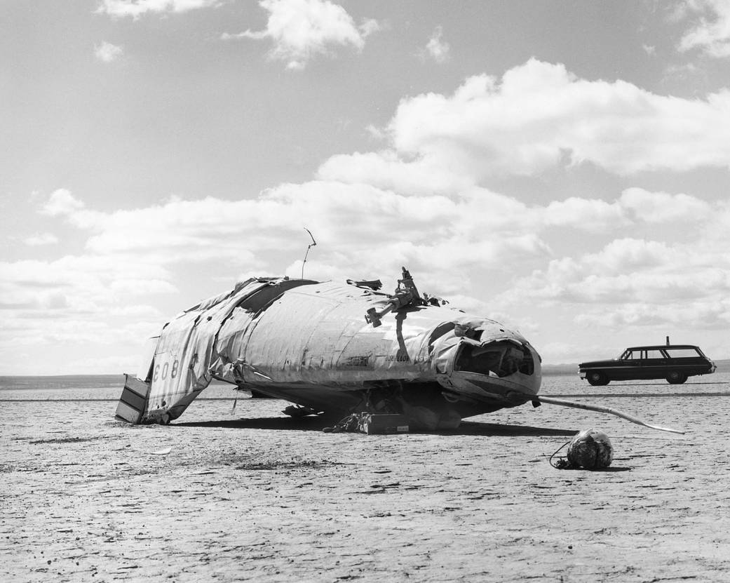  The battered hulk of the M2-F2 lifting body rests upside-down on Rogers Dry Lake after its crash on May 10, 1967.