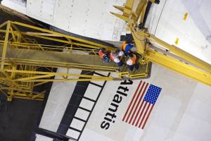 This overhead view, photographed in the Vehicle Assembly Building at NASA's Kennedy Space Center in Florida, shows workers attaching a crane to shuttle Atlantis.