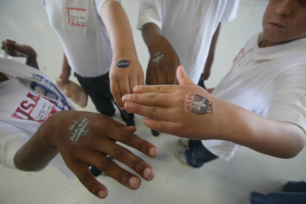 Photo of young visitors, showing off their NASA temporary tatooes placed on their hands at the NASA aeronautics exhibit at the Joint Services Open House and Air Show in May near Washington, D.C.