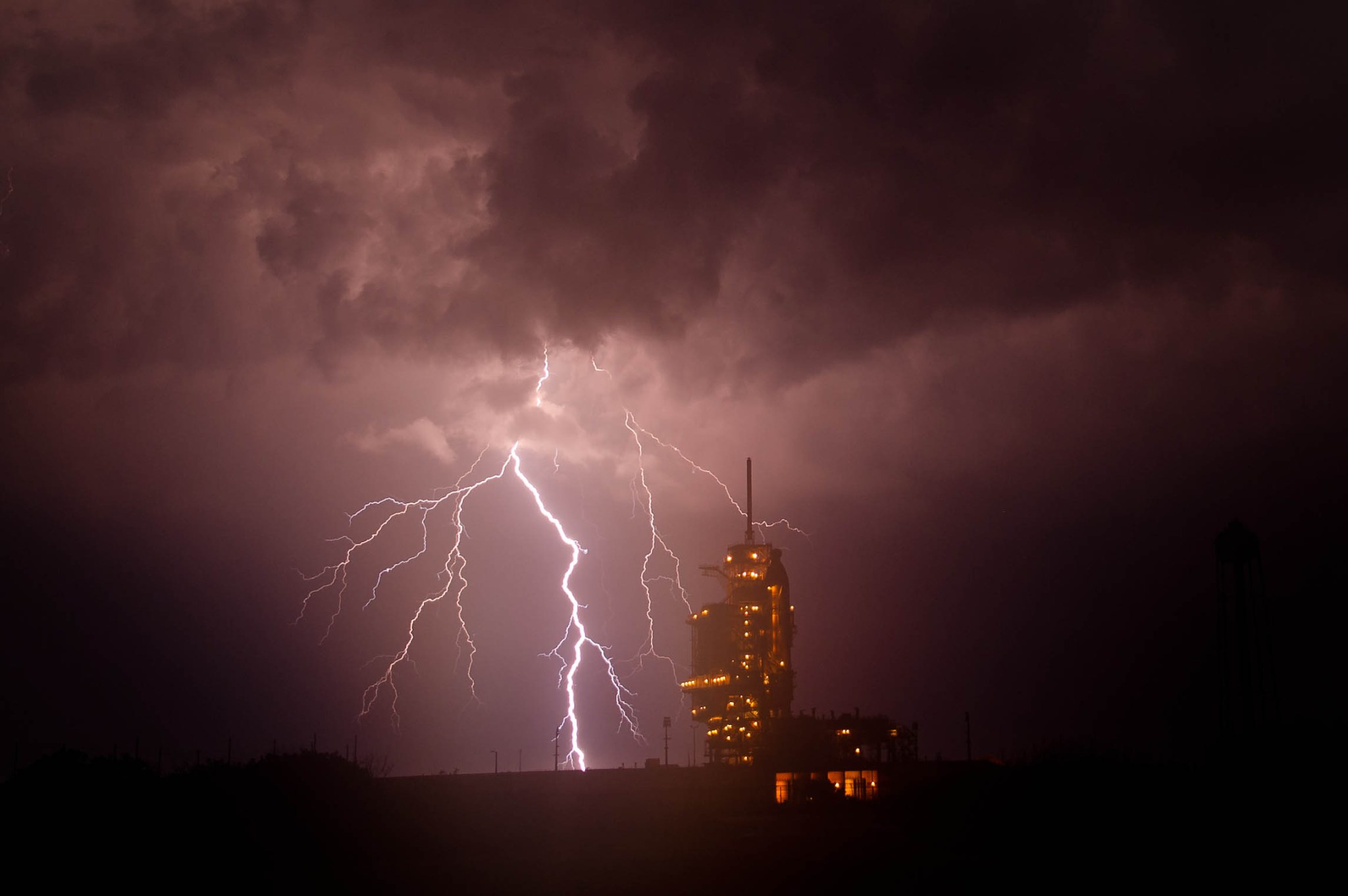 The space shuttle Endeavour is seen on launch pad 39 with lightning in the background