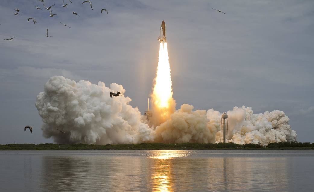 Launch of shuttle Atlantis with water in the foreground