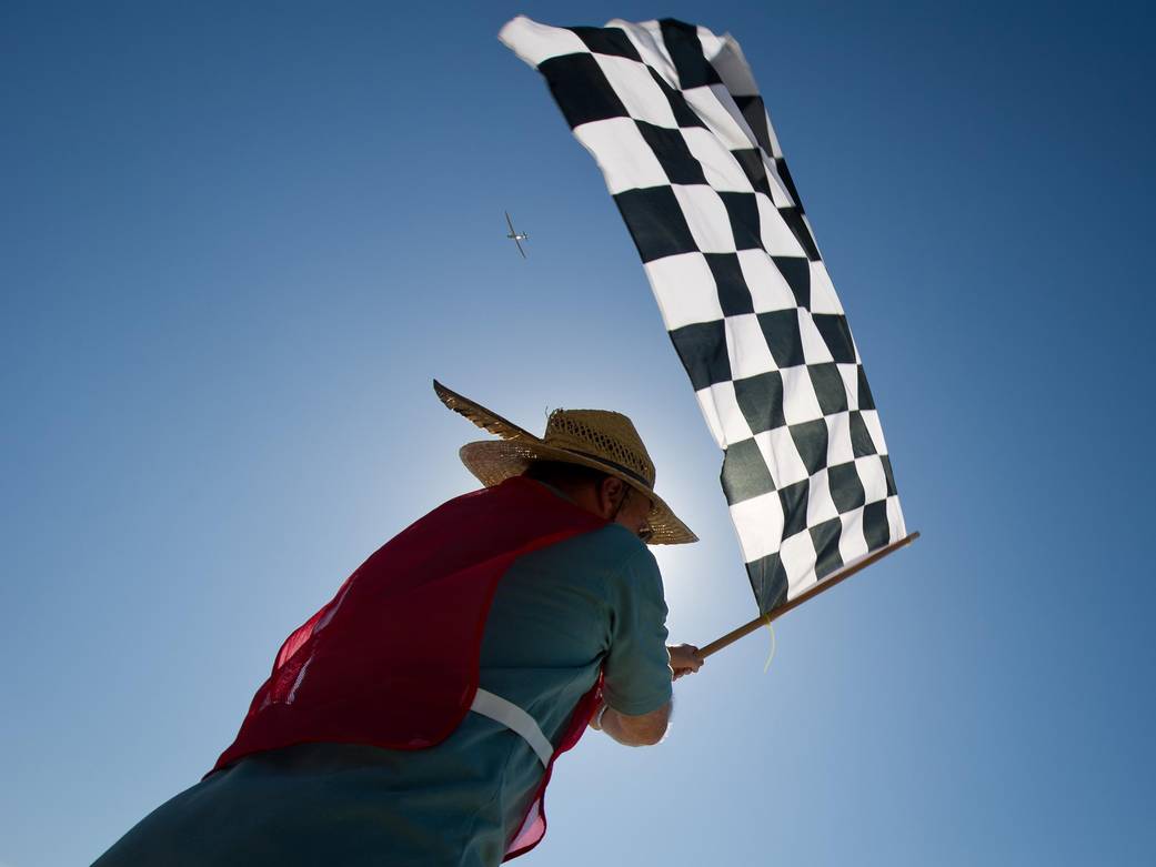 A person waving a black and white checkered flag.