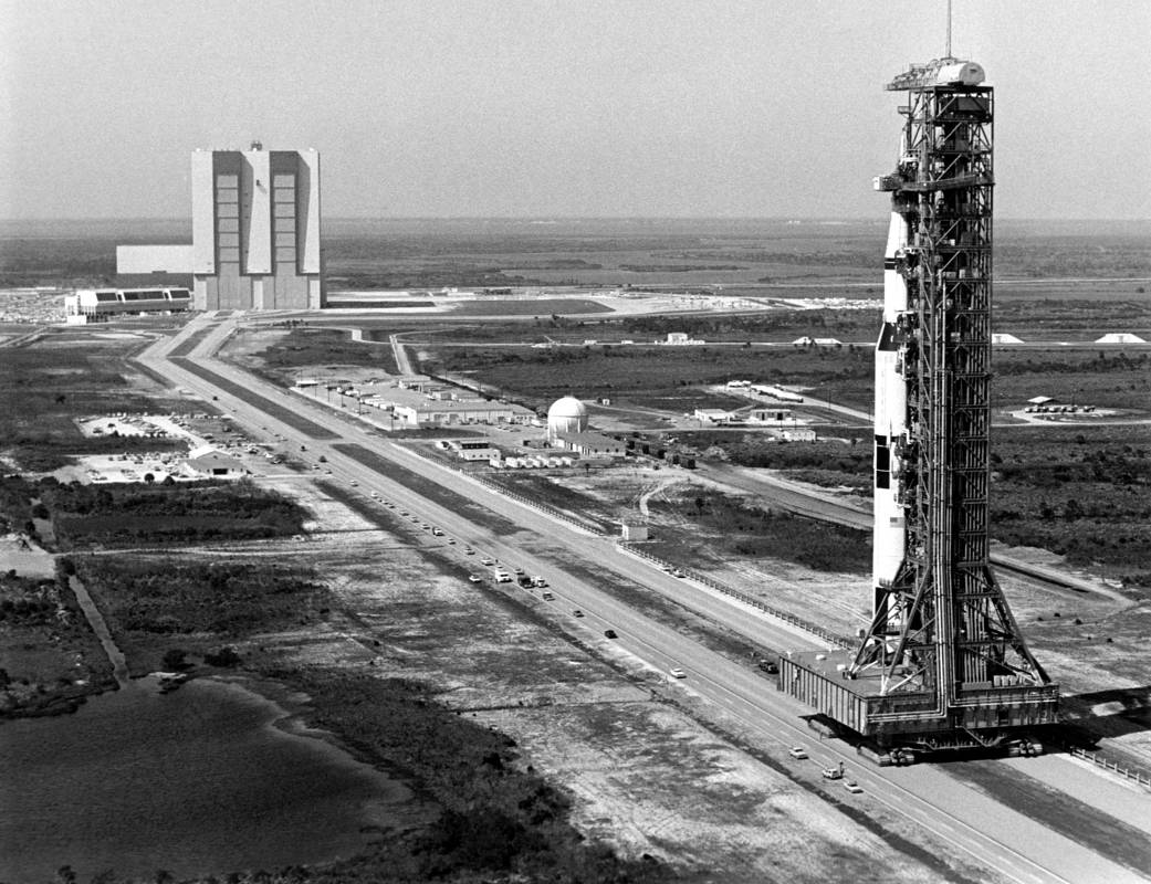The 363-foot-high Saturn V rocket for the Apollo 10 mission towers over the crawlerway during its rollout from the Vehicle Assembly Building to Launch Pad 39B, four miles away. 