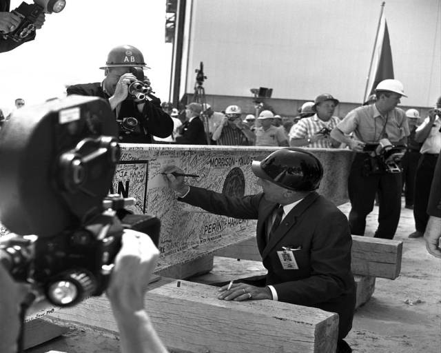 Kurt Debus, the center's first director who served from 1961 to 1974, adds his name to the thousands of signatures affixed to the 38-foot-long steel beam used in the Vehicle Assembly Building's "topping off" ceremonies.