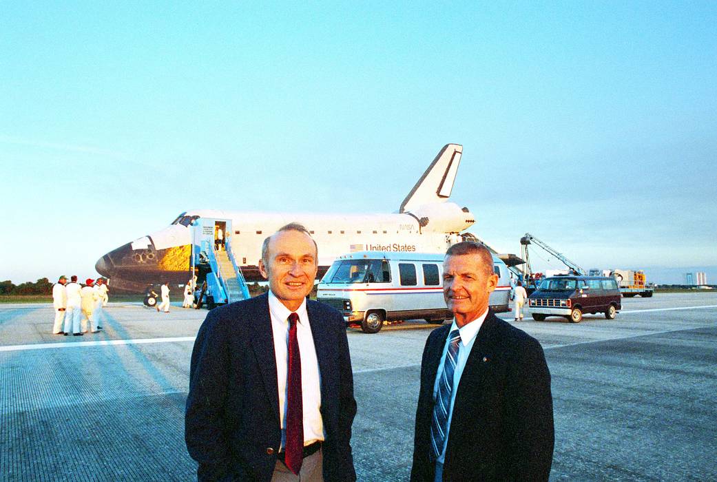 Robert Sieck, launch director, (left) and Forrest McCartney, center director from 1986 to 1991, pose before space shuttle Atlantis.