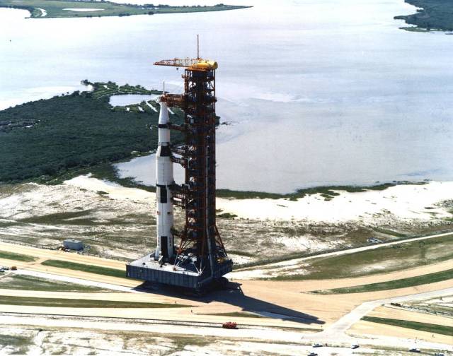 Carrying the Apollo 11 Saturn V rocket and mobile launcher, the crawler inches its way along the three-and-a-half-mile journey to Launch Pad 39A.