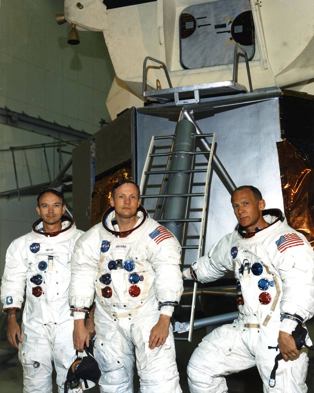 As the Apollo 11 astronauts rehearse their lunar landing mission in simulators, they pause in front of a lunar module mockup in the Flight Crew Training Building area. 