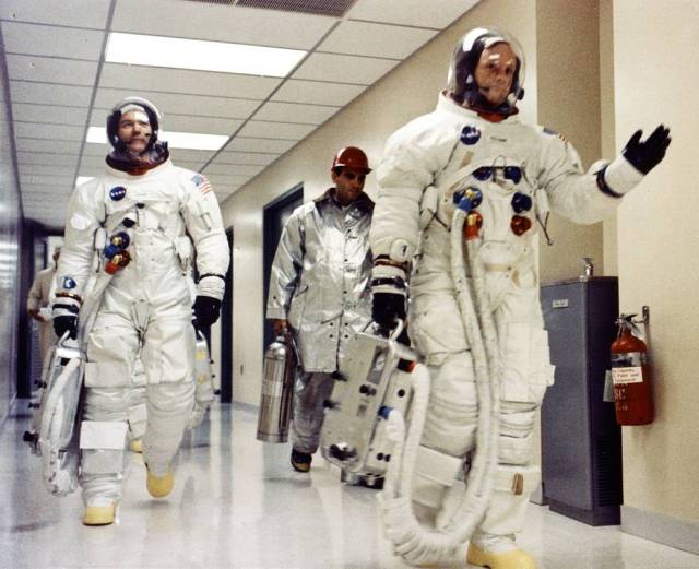 Apollo 11 Commander Neil A. Armstrong waves to well-wishers in the hallway of the Manned Spacecraft Operations Building at Kennedy Space Center.