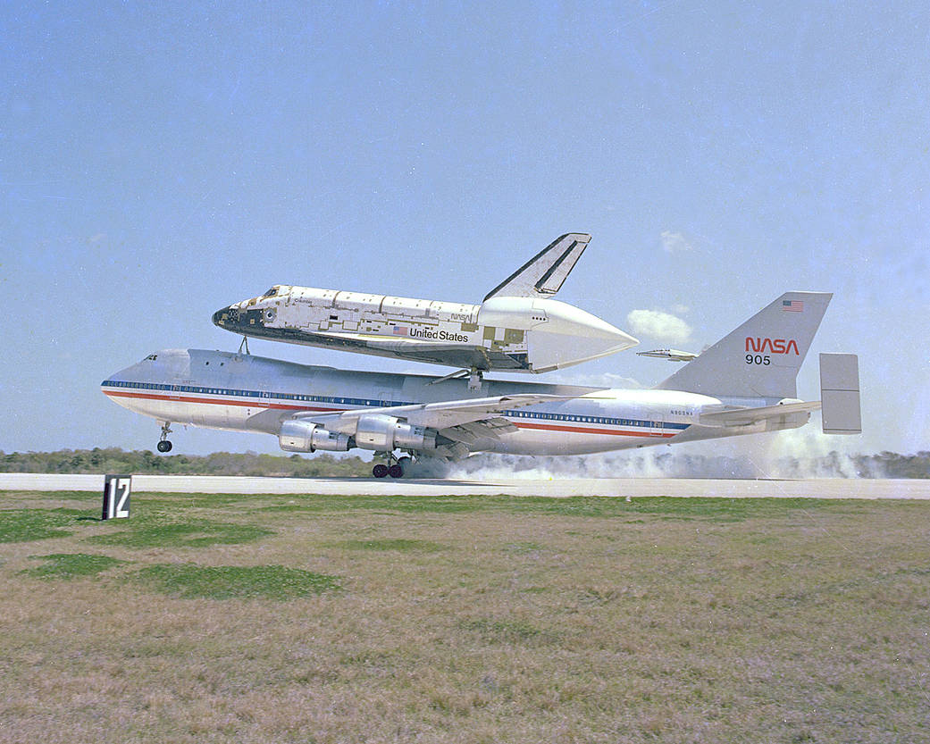 The space shuttle Columbia, piggyback on its 747 carrier aircraft, is only seconds away from a touchdown at Kennedy Space Center's Shuttle Landing Facility.