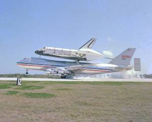 The space shuttle Columbia, piggyback on its 747 carrier aircraft, is only seconds away from a touchdown at Kennedy Space Center's Shuttle Landing Facility.