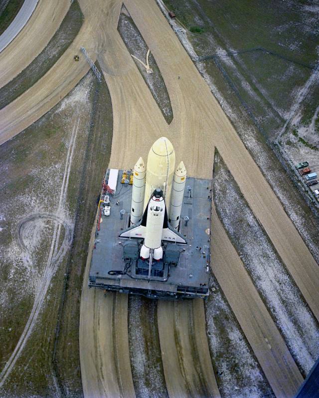 The STS-1 vehicle -- consisting of America's first reusable spaceship, space shuttle Columbia, the external propellant tank and twin solid rocket boosters -- rolls down the crawlerway.