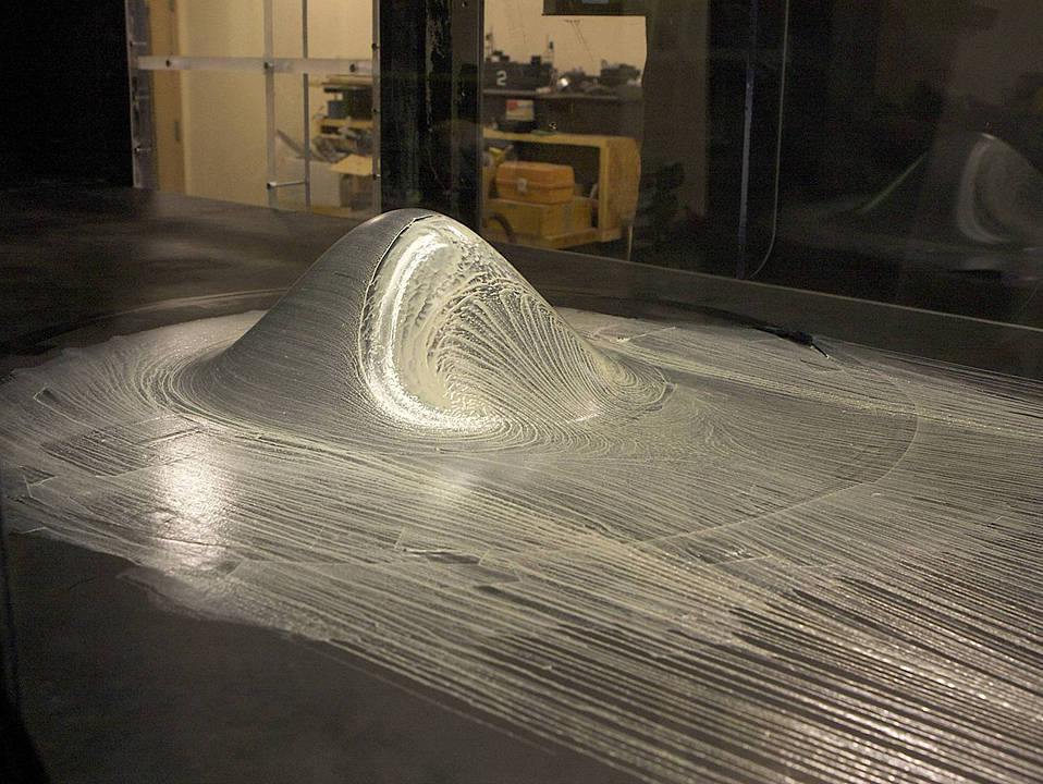 A silver looking hill, axisymmetric hill covered with oil.