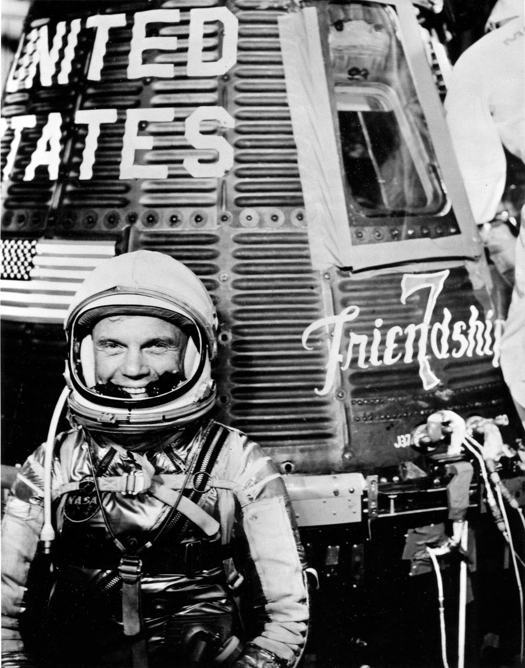 Astronaut John H. Glenn Jr., pilot of the Mercury Atlas 6 (MA-6) spaceflight, with the Mercury "Friendship 7" spacecraft.