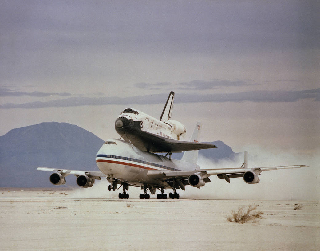 With Space Shuttle Columbia mounted firmly atop, NASA's modified Boeing 747 Shuttle Carrier Aircraft 905 kicks up clouds of gyps