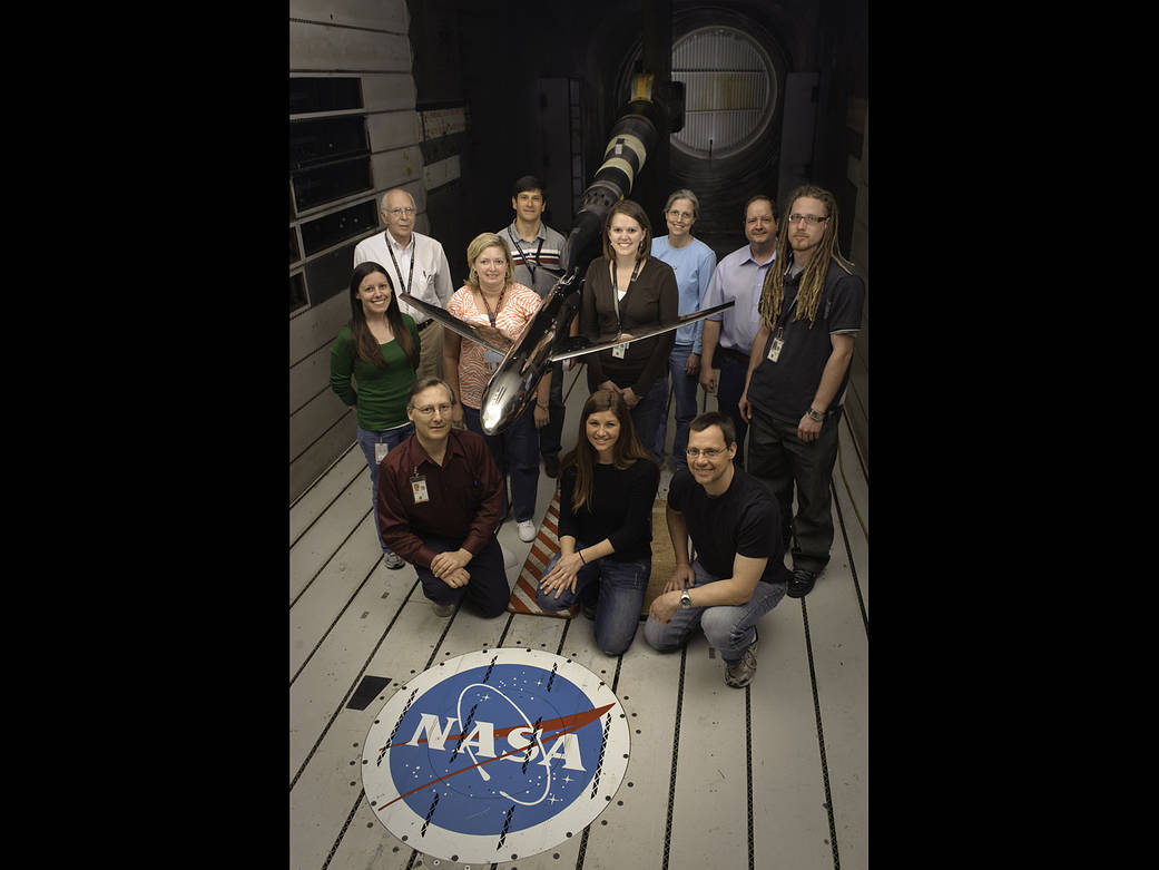 model of generic transport airplane in wind tunnel with Model Test Crew standing nearby