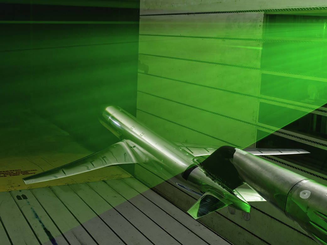 model of generic transport airplane in wind tunnel with green laser beam