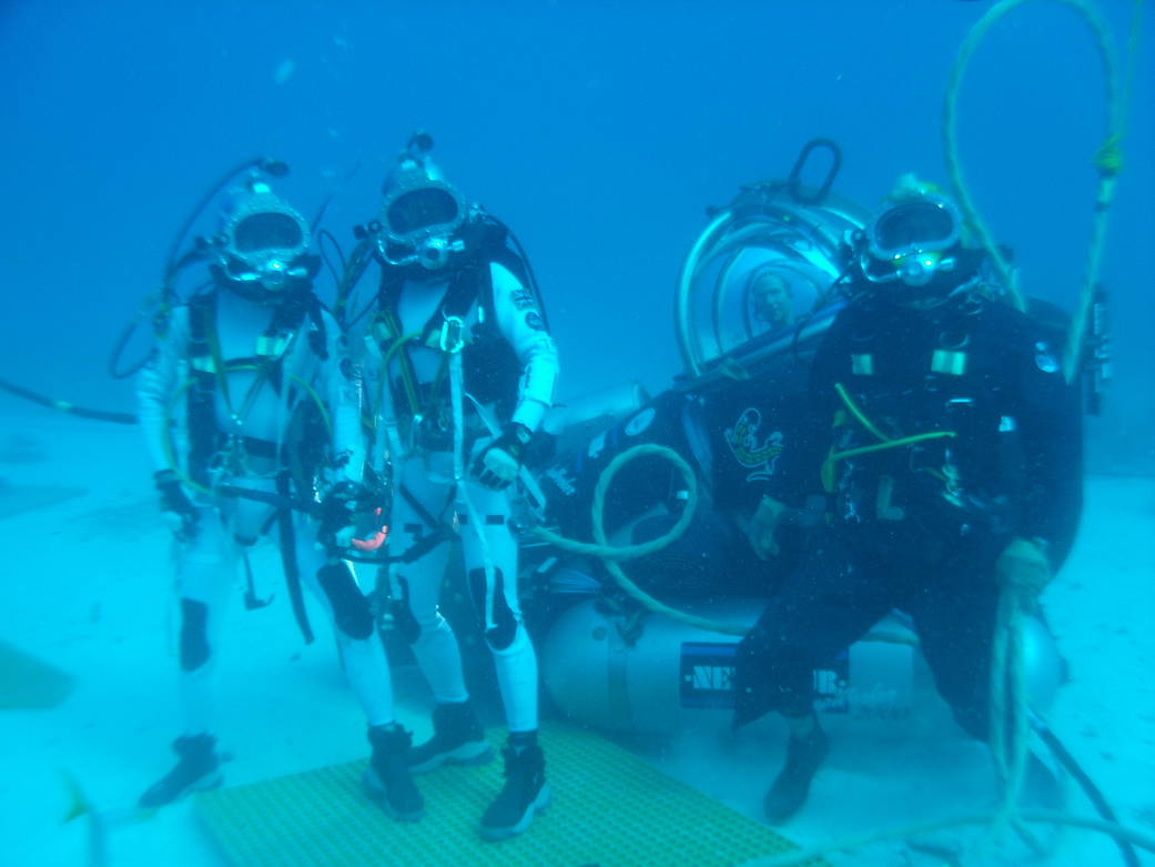 NEEMO 16 aquanauts Kimiya Yui and Tim Peake pose with their support diver and astronaut Mike Gernhardt in the DeepWorker single-