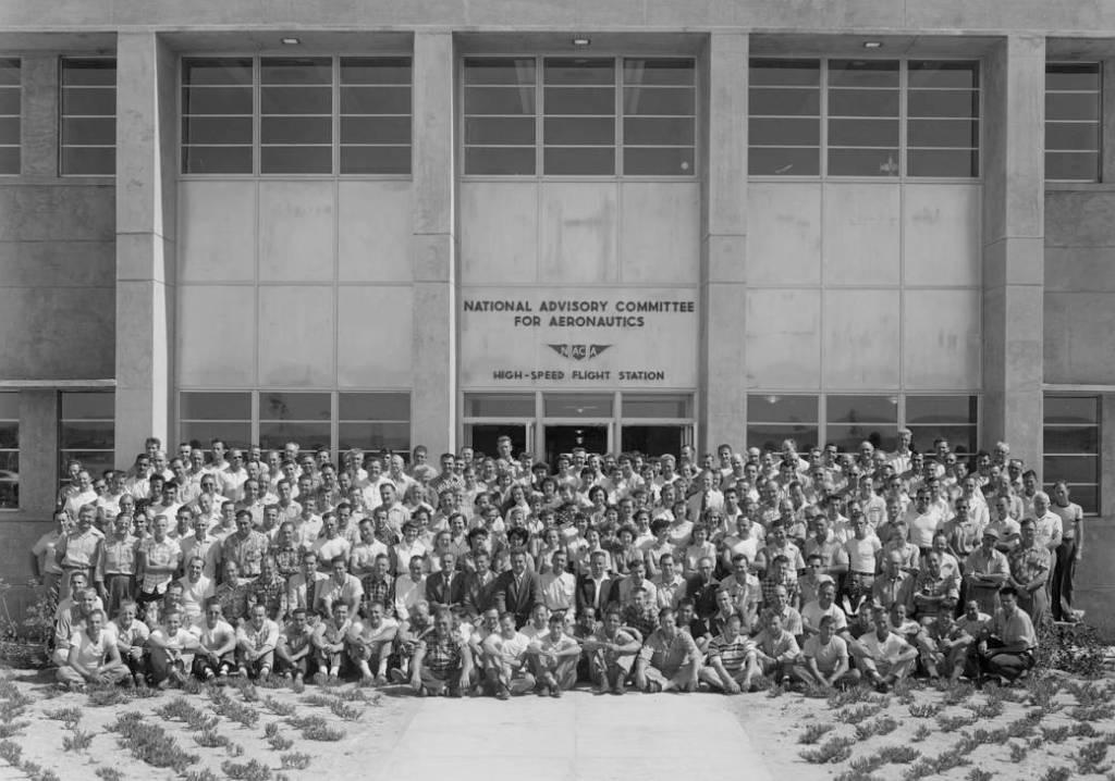 Personnel of the NACA High-Speed Flight Station gathered for a group photo in front of the station's new headquarters, Bldg. 480