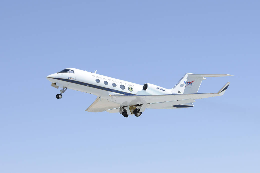 The G-III aircraft in flight against a clear blue sky.