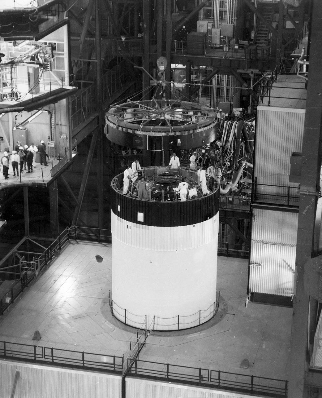 The Instrument Unit is lowered into place atop the third stage of the Saturn V launch vehicle in the Vehicle Assembly Building.