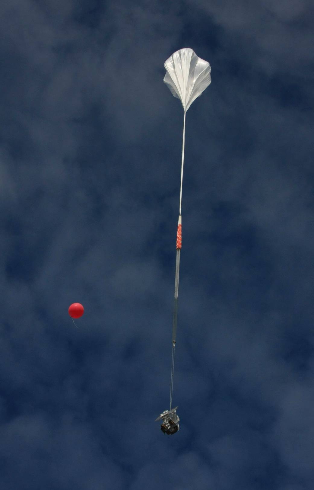 The 7,000-pound SUNRISE solar telescope dangles beneath a 1,000-foot tall balloon as it began its flight from Kiruna, Sweden, in