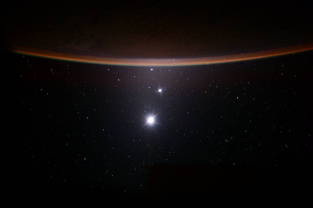 Earth's Moon, Venus, Jupiter and the crescent of Earth at the top.