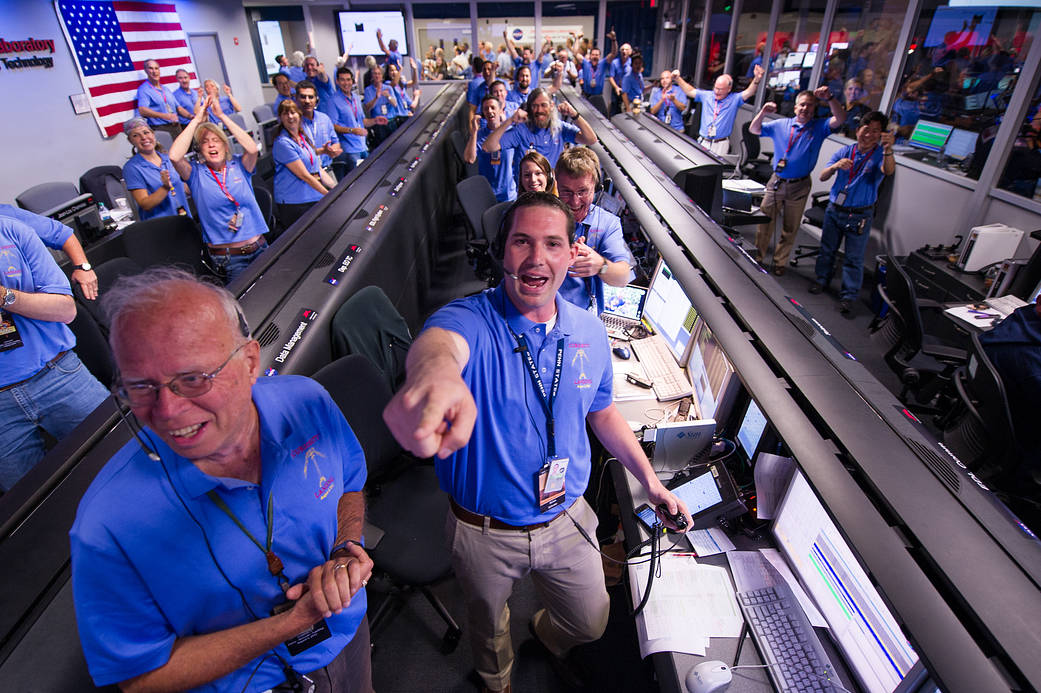The Mars Science Laboratory (MSL) team in the MSL Mission Support Area reacts after learning the Curiosity rover has landed  