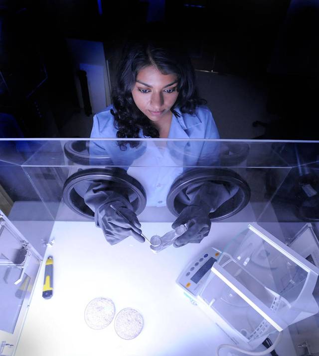 Goddard technologist Nithin Abraham works inside a small cleanroom.