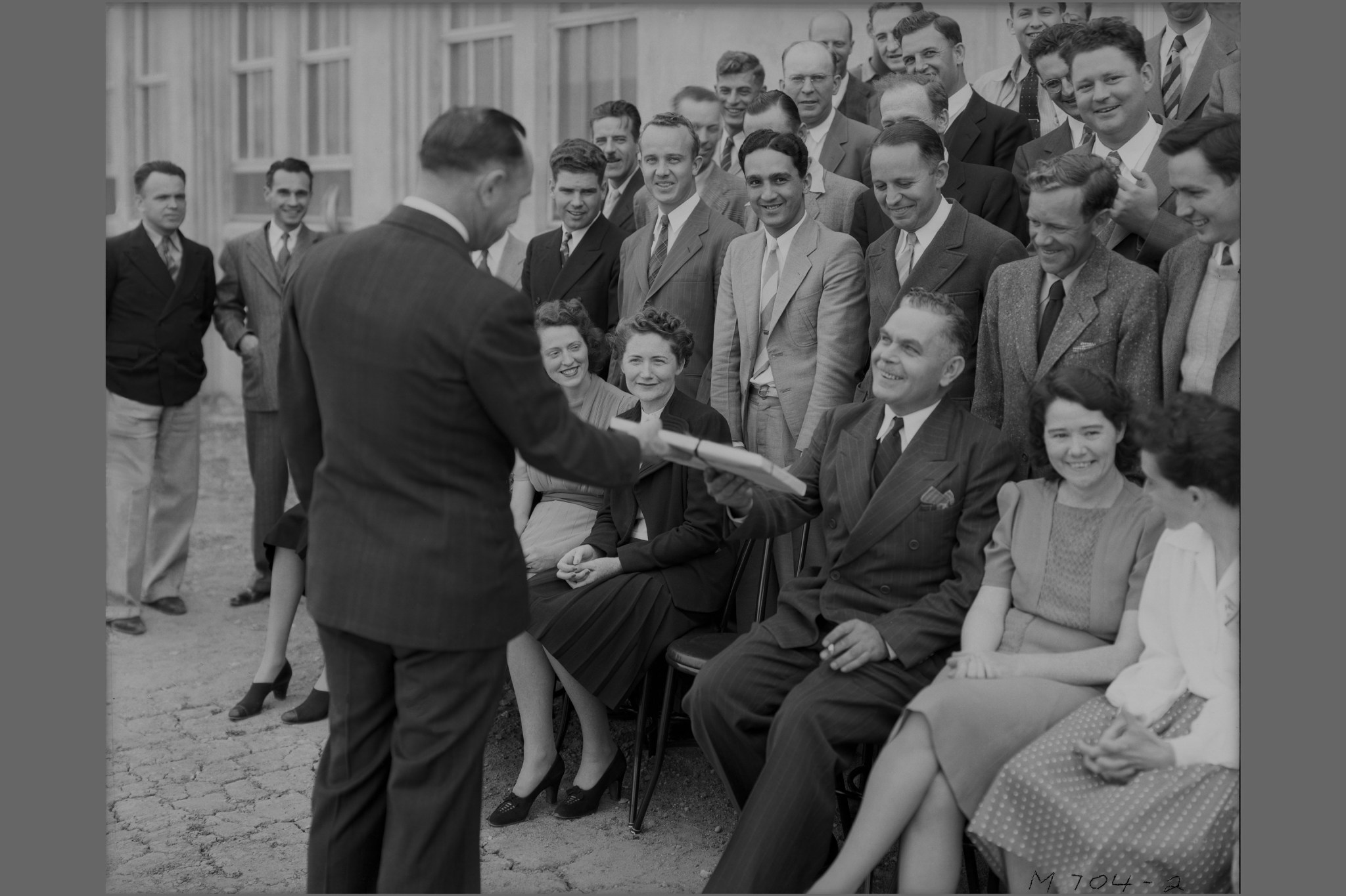 Photograph of Ames Aeronautical Laboratory Director Smith DeFrance greeting original staff members just before before a group photo is taken.