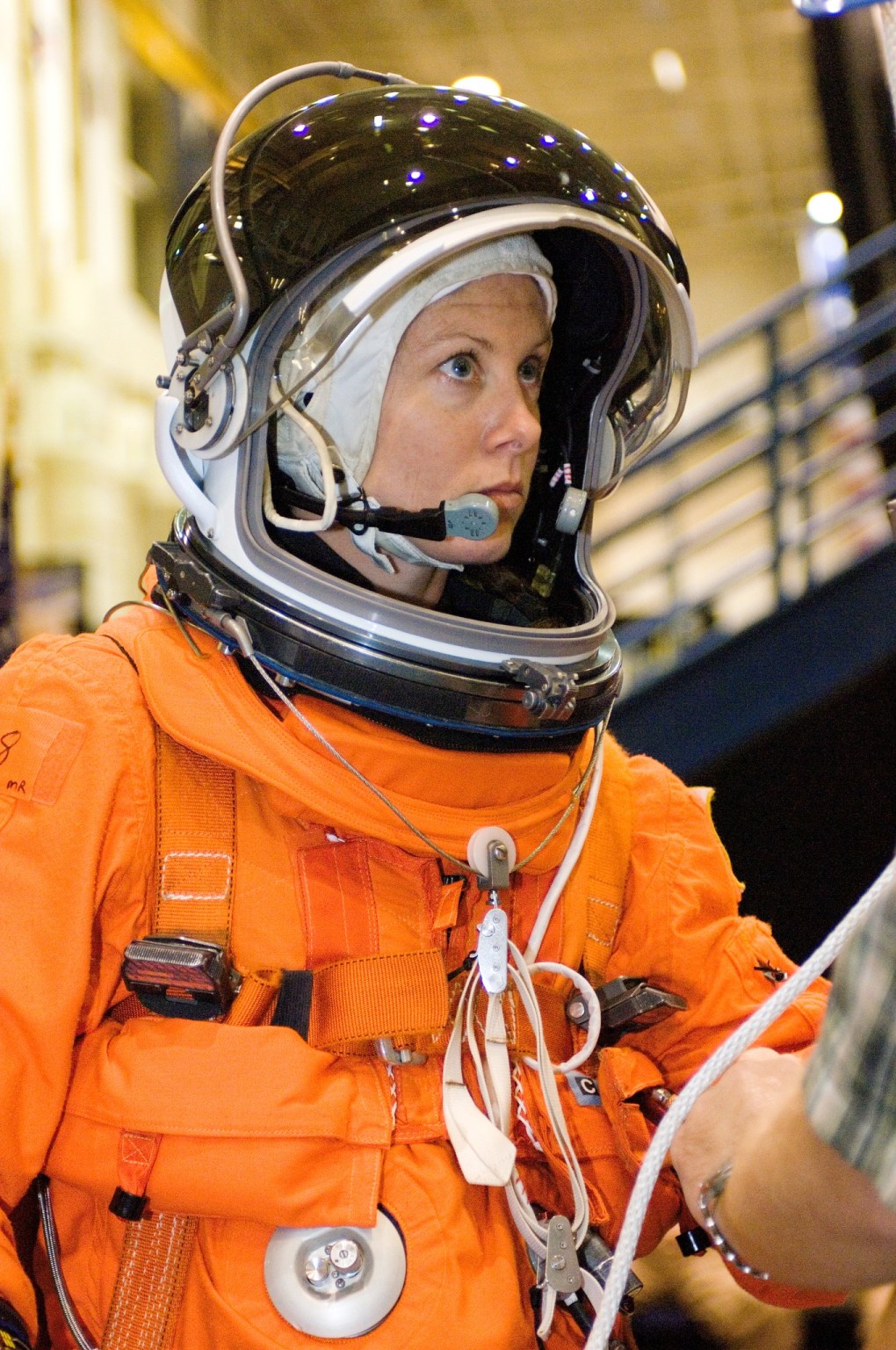 Attired in a training version of her shuttle launch and entry suit, astronaut Tracy E. Caldwell, STS-118 mission specialist, participates in a training session on the usage of a special device, used to lower oneself from a troubled shuttle, in the Space Vehicle Mockup Facility at the Johnson Space Center.