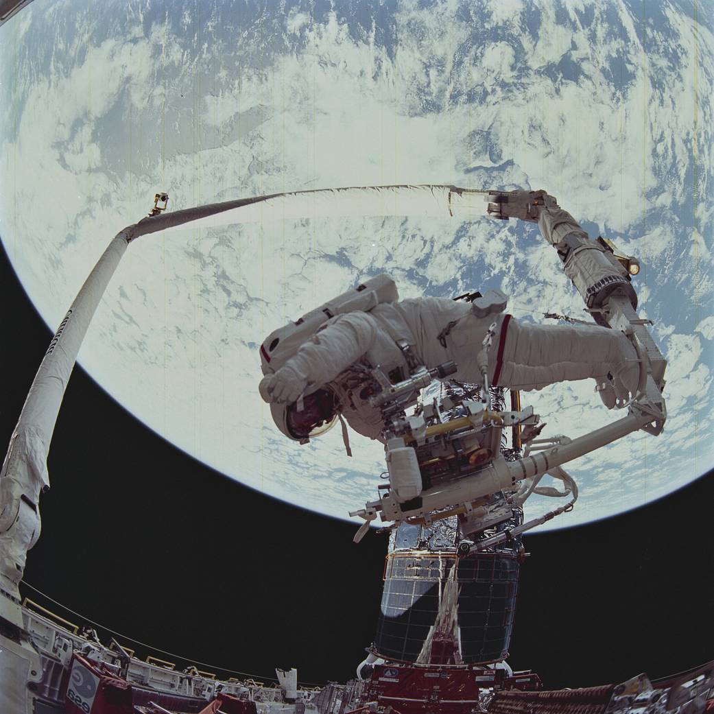 Space Shuttle mission STS-61 onboard view taken by a fish-eyed camera lens showing astronauts Story Musgrave and Jeffrey Hoffman's Extra Vehicular Activity (EVA) to repair the Hubble Space Telescope (HST).