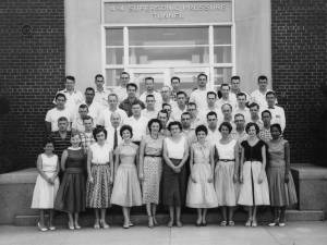 Black and white photograph of staff standing in front of supersonic pressure tunnel building