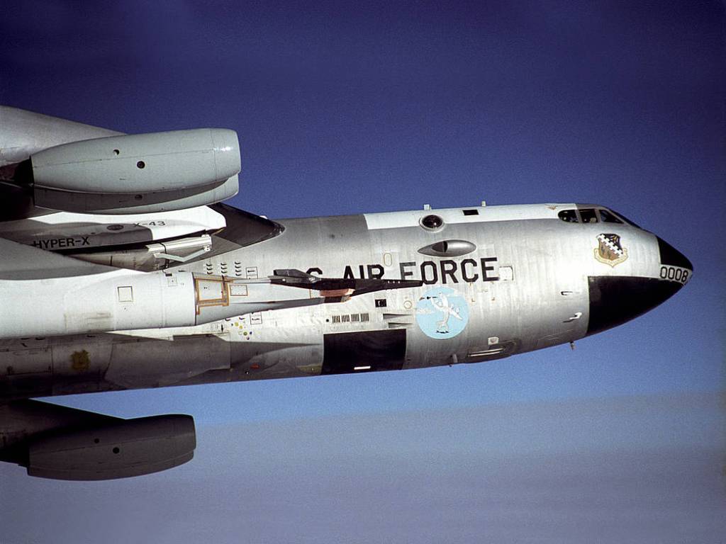 The X-43 seen here is the small black aircraft attached to the nose of a modified Pegasus booster rocket, which is hung from a p