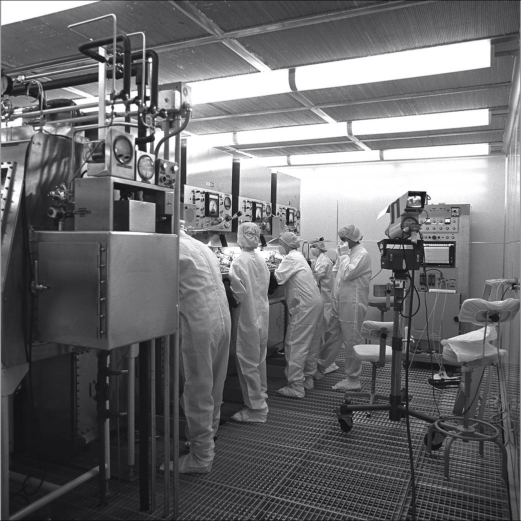 A line of scientists in a lab operating on lunar samples.