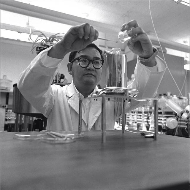 Branch Chief Vance Oyama pouring lunar soil samples into a distribution system.