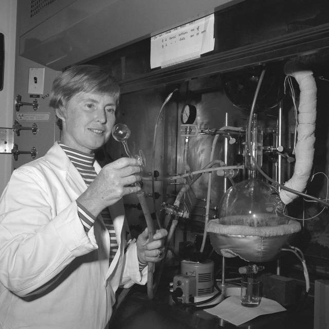 Chemist Patricia Kirk operating a device with a glass bulb and tubes.