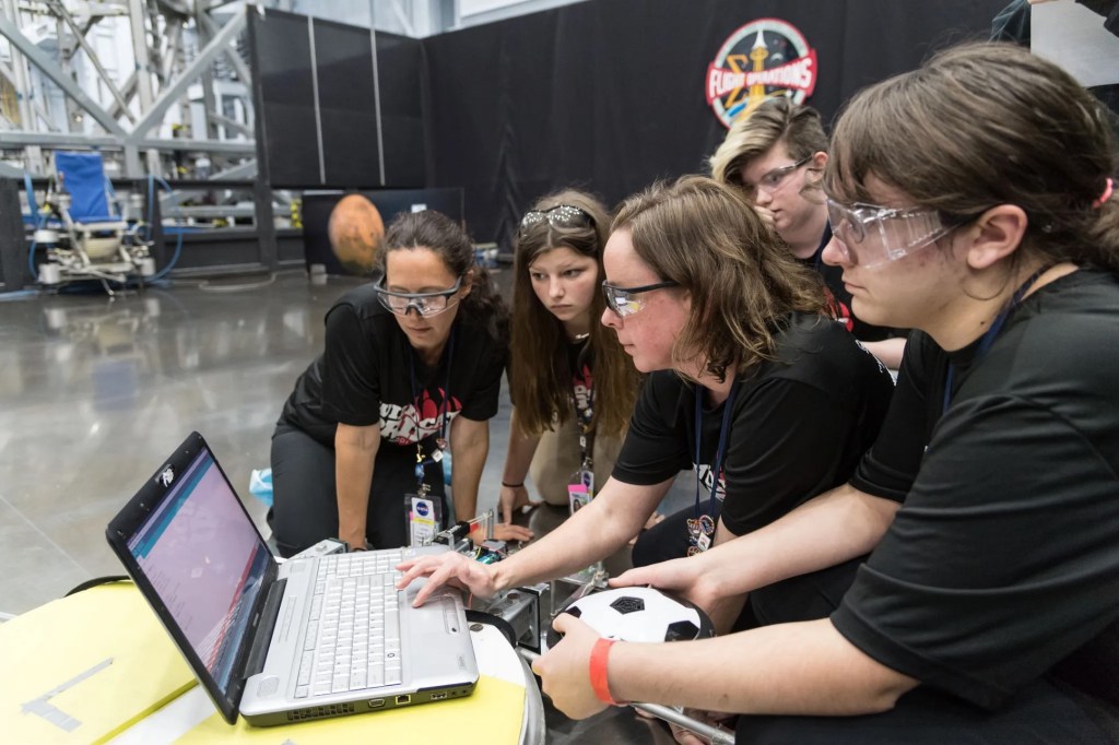 A group of students work on a computer for the NASA App Development Challenge.