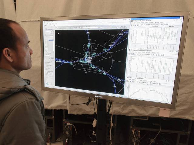 A NASA aeronautics researcher looking at simulations of new air traffic management tools on a large screen.