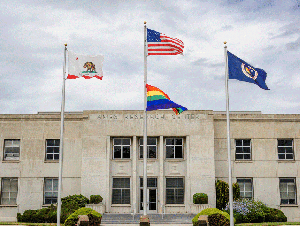 California, US, rainbow and NASA flags in front of the administration building at NASA's Ames Research Center.