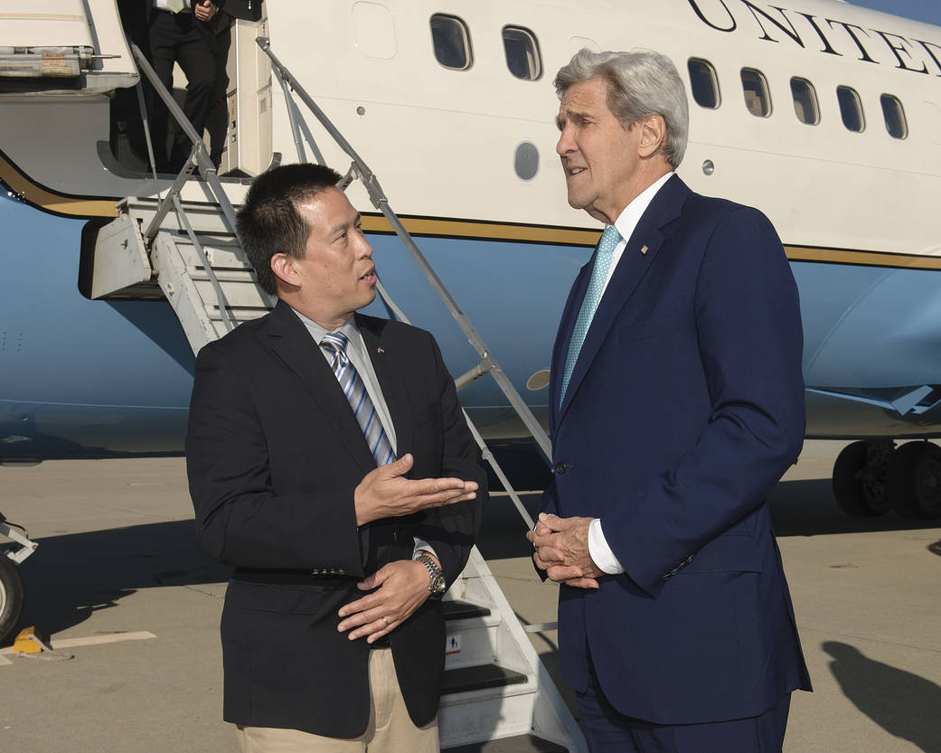 Ames Center Director Eugene Tu greets Secretary John Kerry as he arrives at Moffett Field on June 
