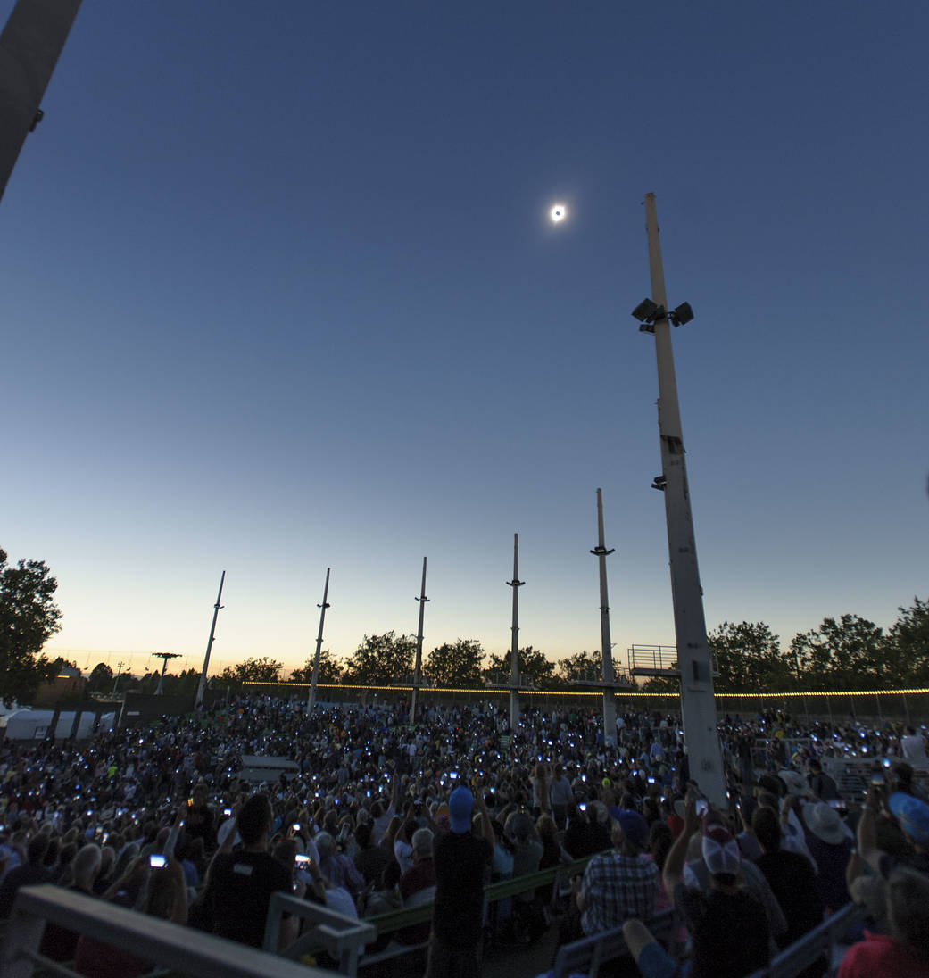 Solar Eclipse totality in sky above and crowd below watching