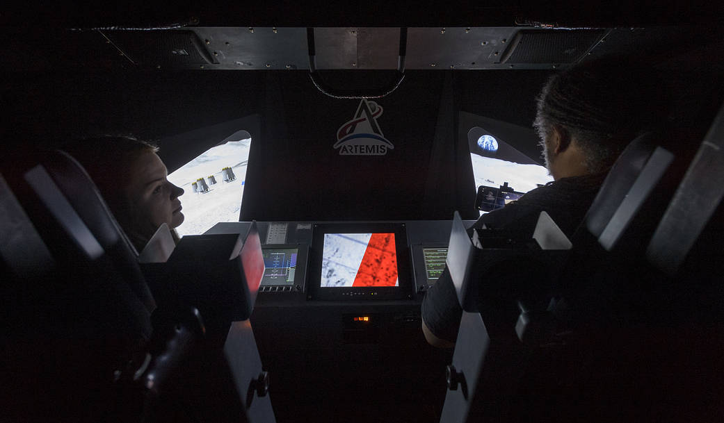 interior of the lunar lander simulator with two participants in front of controls