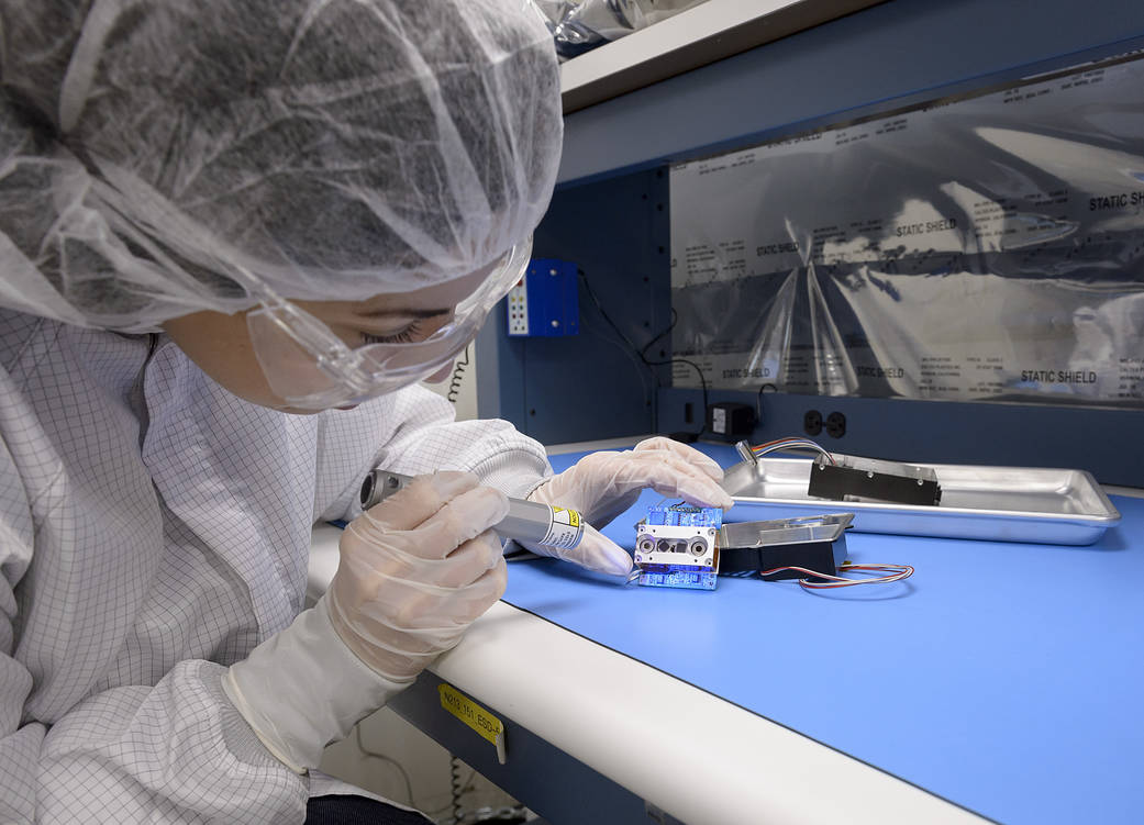 Integration engineer, Amanda Cook, uses ultraviolet light to inspect infrared detectors.