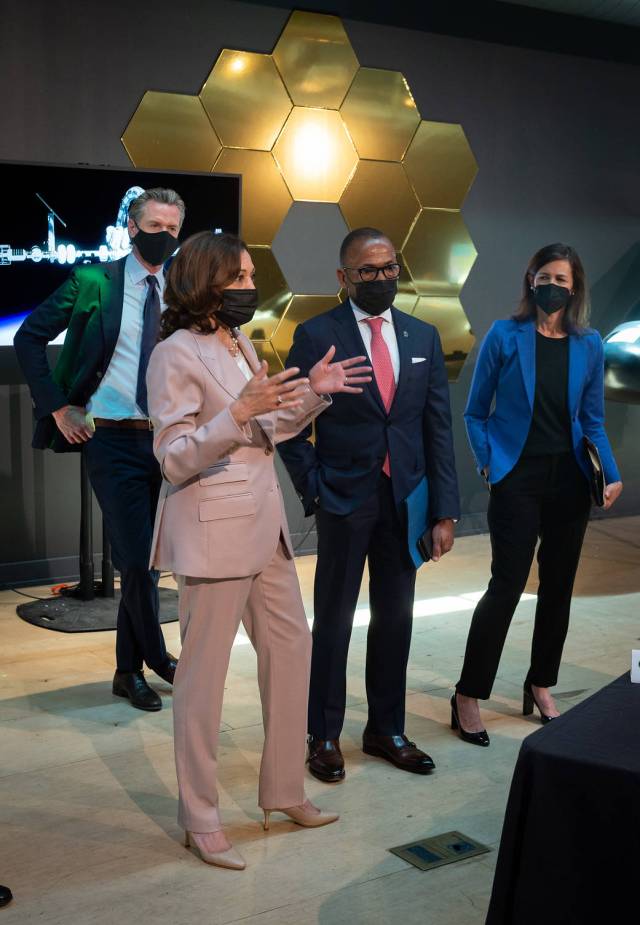 Vice President Kamala Harris stand speaking with attendees at a National Space Council meeting, with Governor of California Gavin Newsom behind