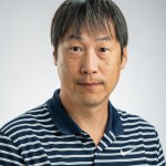 Portrait of Hirofumi Hashimoto in a blue and white striped polo shirt.
