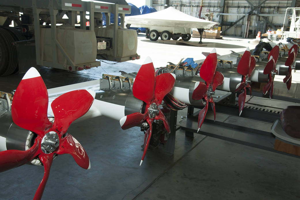 A modified, experimental wing with electric motors is prepared for mounting on top of a modified truck.