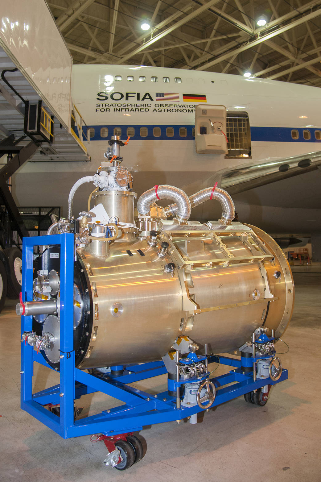 large optical unit in the foreground, SOFIA airplane in the background