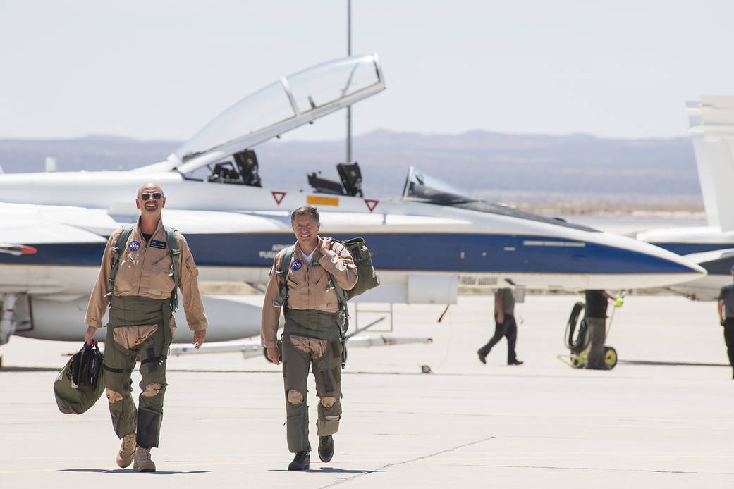 NASA pilot Nils Larson, and flight test engineer Wayne Ringelberg, head for a mission debrief after flying a NASA F/A-18.