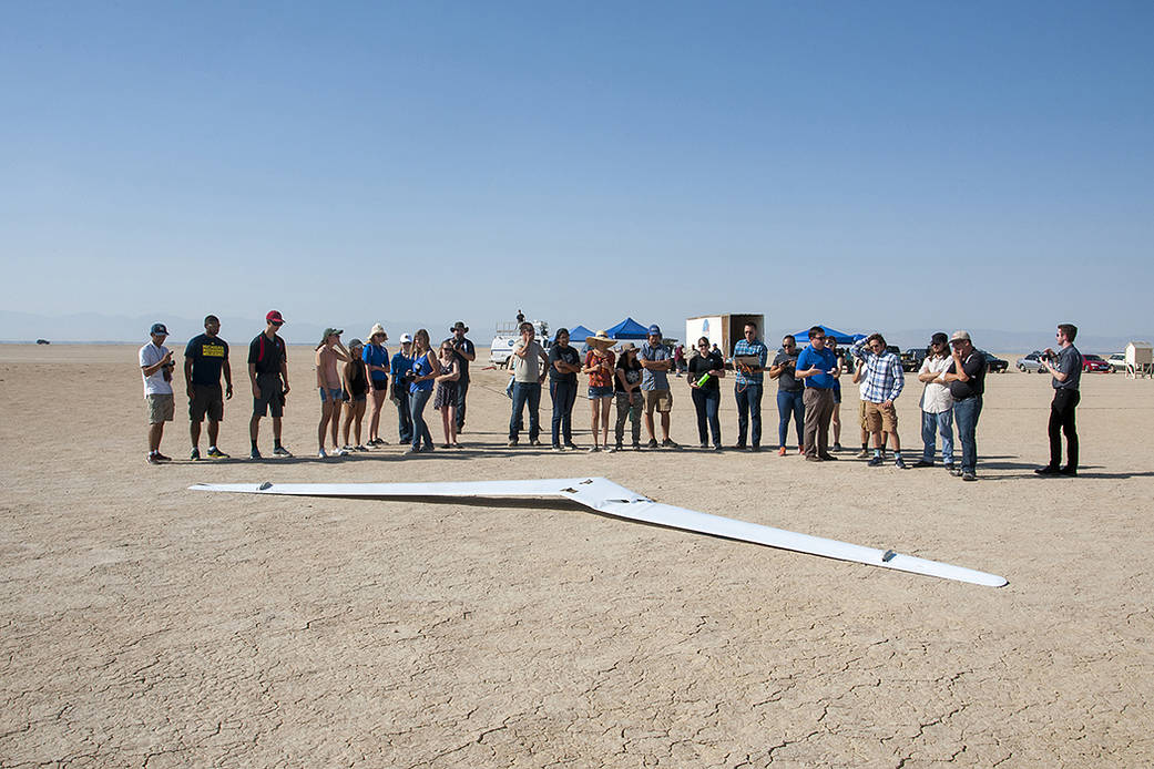 Student interns and NASA personnel cluster in front of PRANDTL-D No. 3 following a crash on Rosamond Dry Lake.